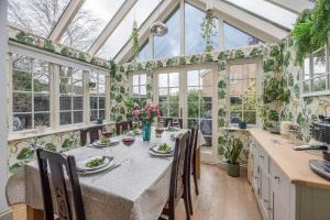 a dining room with a table in a conservatory at Little Cottage Wickham Market Air Manage Suffolk in Woodbridge
