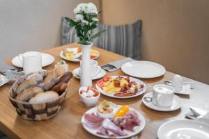 a wooden table with plates of food on it at Galerie Hotel in Bad Reichenhall