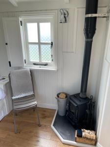 a kitchen with a stove and a chair and a window at The Hut by the River in York