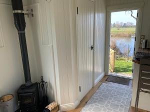 a kitchen with a stove and a door with a view at The Hut by the River in York