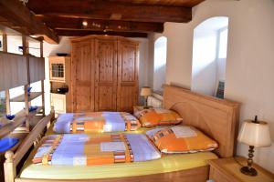 two beds in a bedroom with wooden ceilings at Hackerhof-Suedwohnung in Morsum