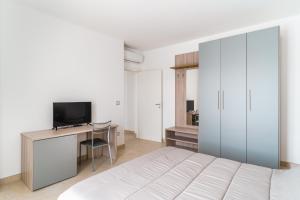 Un dormitorio con una cama y un escritorio con televisión. en Scaringi Palace A, en Trani