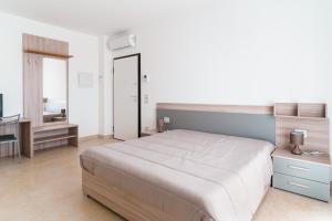 Un dormitorio con una cama grande y un escritorio. en Scaringi Palace A, en Trani