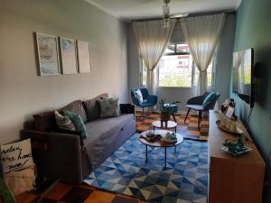 sala de estar con sofá y mesa en APARTAMENTO PRAIA GRANDE-CANTO DO FORTE- 2 QUADRAS DA PRAIA WI-FI,NETFLIX e ESTACIONAMENTO en Praia Grande