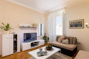 a living room with a couch and a tv at Villa Falkoni II in Dubrovnik