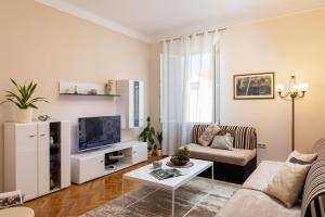 a living room with a couch and a tv at Villa Falkoni II in Dubrovnik