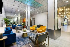 um átrio com mesas e cadeiras azuis e amarelas em OYO Times Square em Nova Iorque
