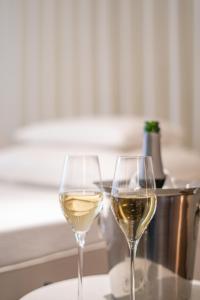 deux verres de vin blanc assis sur une table dans l'établissement Galerie Hotel, à Bad Reichenhall