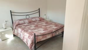 a bedroom with a bed with a pink comforter at Le 4 Stagioni in Comacchio