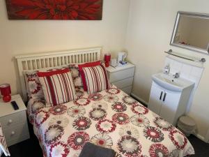 a bedroom with a bed and a dresser at Melrose Guest House in Whitley Bay