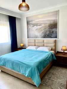 Soma Bay Apartment في الغردقة: غرفة نوم بسرير ازرق مع لوحة على الحائط