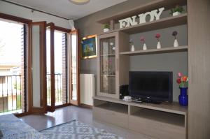 a living room with a flat screen tv on a shelf at Montello Apartment Noale in Noale