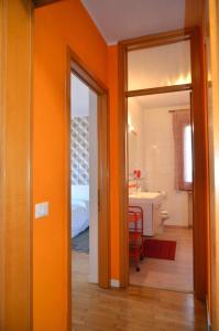 een oranje kamer met een badkamer met een wastafel bij Montello Apartment Noale in Noale