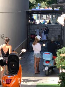 Una mujer está parada al lado de una moto. en Hostel Split en Split
