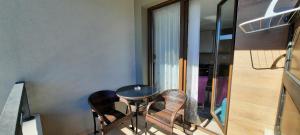 un pequeño balcón con mesa y sillas. en apartment zlatibor, en Zlatibor