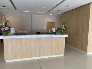 a hotel lobby with a reception counter with flowers at Brava P14 - 1 dorm. (sin sabanas y sin toallas) in Punta del Este +26 photos