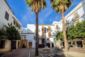 un patio con palmeras frente a un edificio en Apartamento céntrico en Plaza San Miguel, en Córdoba