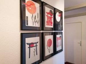 a group of framed pictures hanging on a wall at Loft "im Alten Pfarrhaus" in Neuruppin