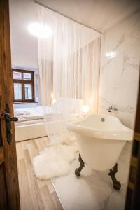 een witte badkamer met een wastafel en een bad bij Стильна квартира в центрі на Площі Ринок вулиця Галицька 9 in Lviv
