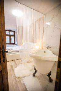 a white bathroom with a sink and a tub at Стильна квартира в центрі на Площі Ринок вулиця Галицька 9 in Lviv