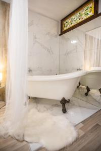 a white bathroom with a tub and a shower at Стильна квартира в центрі на Площі Ринок вулиця Галицька 9 in Lviv