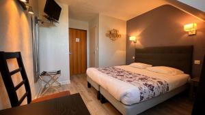 um quarto de hotel com uma cama e uma mesa em Hotel des Voyageurs em Tarnac