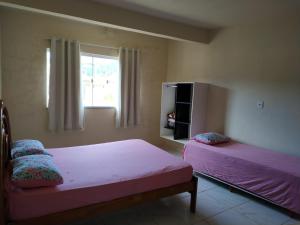 a bedroom with two beds and a window at RECANTO BUSCAPE in Alto Caparao