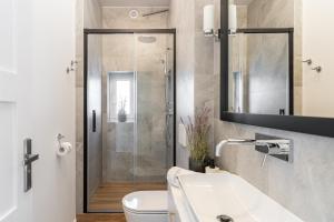 uma casa de banho com um chuveiro, um WC e um lavatório. em Lion Apartments - London em Sopot