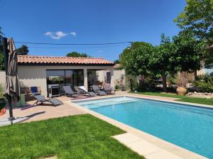 a swimming pool in front of a house at La Maison des Romarins Chambres d'hôtes Cosy Climatisées Piscine Cuisine in Aigremont