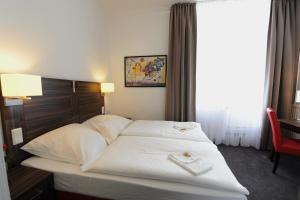 ein Bett in einem Hotelzimmer mit zwei Handtüchern darauf in der Unterkunft Best Western Hotel Kaiserhof in Bonn