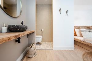 Un baño con lavabo, inodoro y espejo. en Marley’s Beachhouse - Luxury Apartment with garden, en Zandvoort 48 fotos más