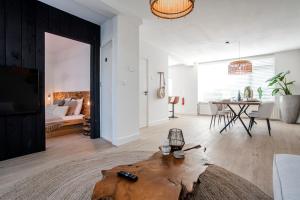 una sala de estar con un sofá y una mesa en Marley’s Beachhouse - Luxury Apartment with garden, en Zandvoort