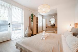 Un dormitorio con una cama grande y una ventana grande en Marley’s Beachhouse - Luxury Apartment with garden, en Zandvoort