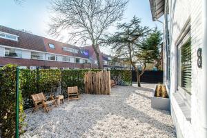 un patio con 2 sillas y una valla en Marley’s Beachhouse - Luxury Apartment with garden, en Zandvoort