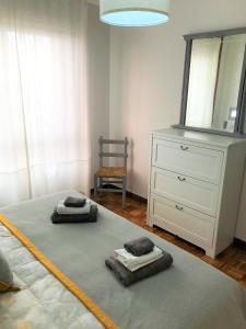 een slaapkamer met een bed, een dressoir en een spiegel bij Tranquilidad al lado del Centro Parking incluido in Oviedo