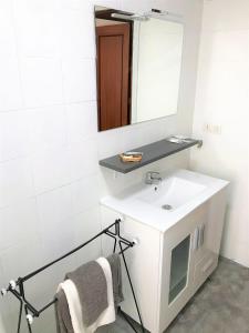 ein Badezimmer mit einem weißen Waschbecken und einem Spiegel in der Unterkunft Tranquilidad al lado del Centro Parking incluido in Oviedo