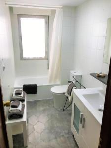 a bathroom with a sink and a toilet and a window at Tranquilidad al lado del Centro Parking incluido in Oviedo