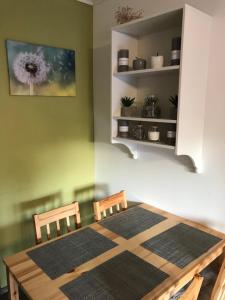 uma sala de jantar com uma mesa de madeira e 2 cadeiras em Pitypang Apartman em Gyula