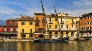Un barco estacionado en el agua frente a los edificios. en Turazza Apartments, en Malcesine