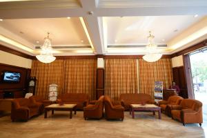 a waiting room with couches and tables and chandeliers at RATHNA RESIDENCY in Coimbatore