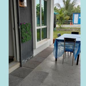 einem blauen Tisch und Stühlen außerhalb eines Gebäudes in der Unterkunft Homestay Lestari KLIA in Sepang