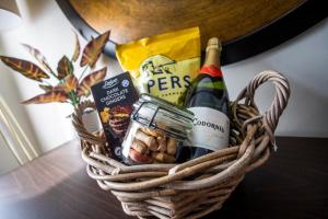 a basket filled with wine and snacks on a table at Luxury Warwick Townhouse I Walk to Castle I Dog friendly I Private patio garden I in Warwick