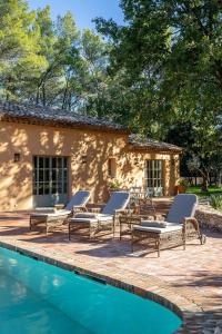 a patio with lounge chairs and a swimming pool at Les Villas du Château de Berne in Lorgues