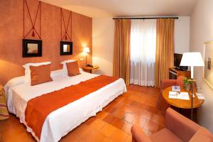 a hotel room with a large bed and a table at Hospederia de Santo Domingo in Pedraza-Segovia