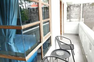 a balcony with two chairs and a glass window at Tiray Homestay Syariah Yogyakarta Mitra RedDoorz in Salakan