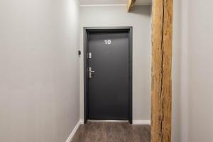 - une porte noire dans une chambre aux murs blancs dans l'établissement Apartament Starówka 10 (Miodova), à Toruń