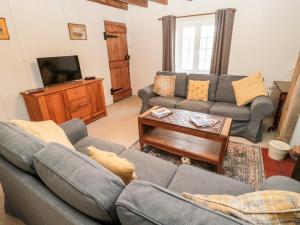 sala de estar con 2 sofás y TV en 2 Redeswood Cottages, en Bellingham