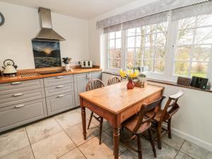cocina con mesa de madera y sillas en 2 Redeswood Cottages, en Bellingham