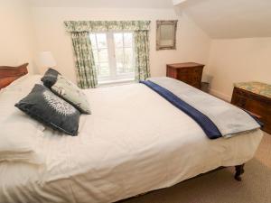 a bedroom with a white bed with pillows and a window at 2 Redeswood Cottages in Bellingham