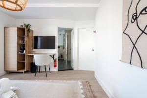 sala de estar con TV y escritorio en Marley’s Beachhouse - Luxury Guest Room with balcony, en Zandvoort